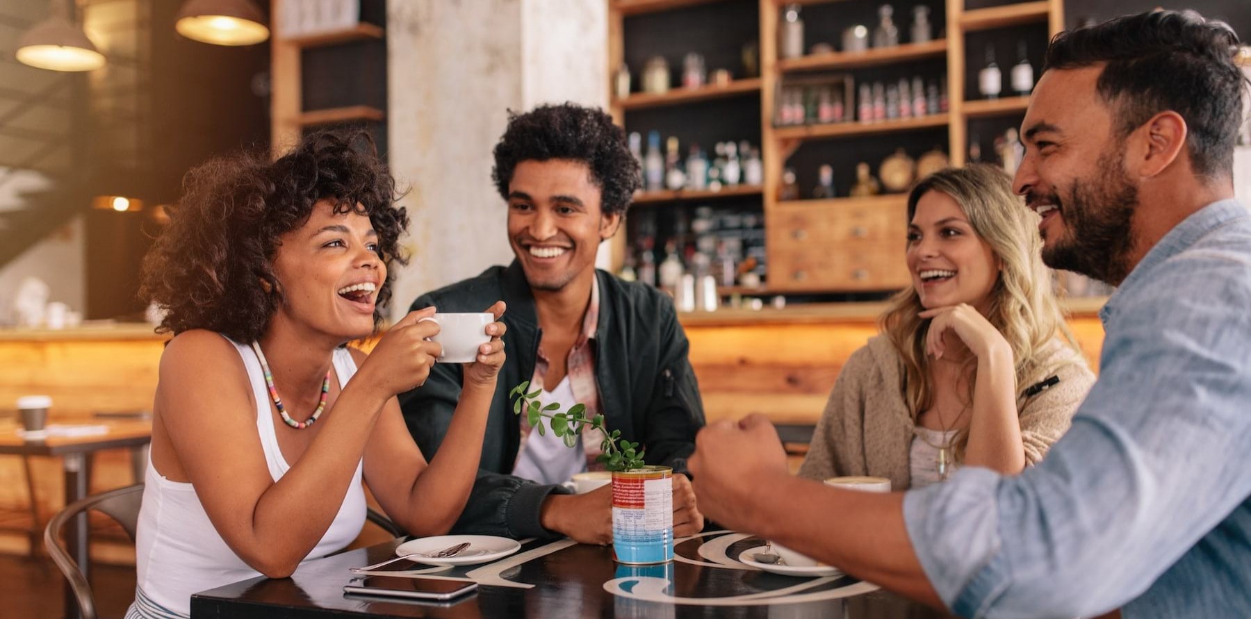 lifestyle image of a group of people laughing over a meal